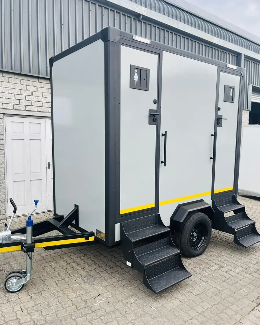 White two-stall restroom trailer with separate doors and fold-down steps